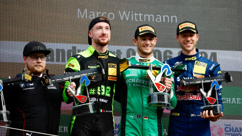 Marco Wittmann levant son trophée sur le podium après sa victoire émouvante à Zandvoort en DTM 2024.