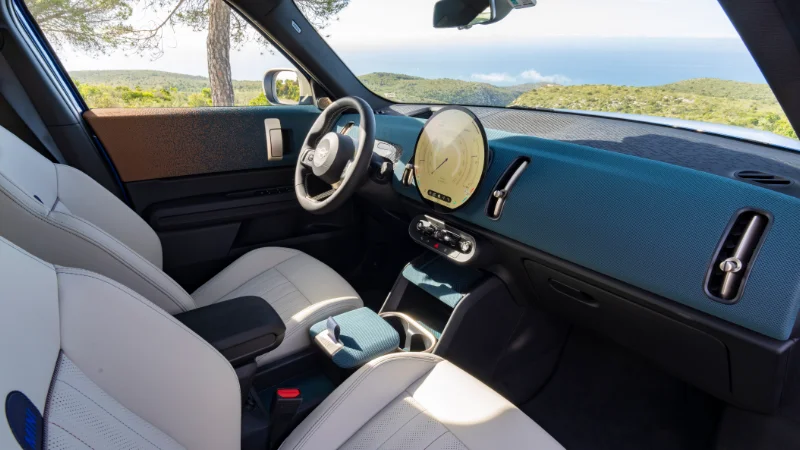 Intérieur du MINI Countryman E montrant le cockpit avec écran OLED et toit panoramique en verre