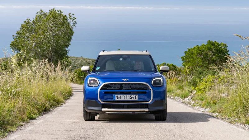 Vue avant du MINI Countryman E en couleur Blazing Blue sur route